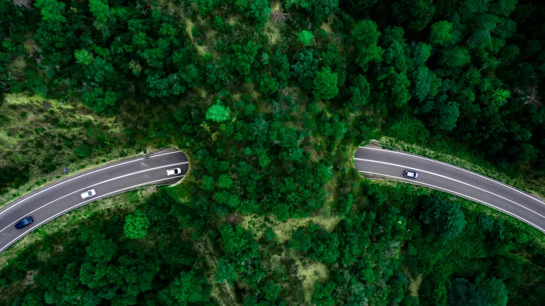 Aerial view of green bridge corridor for wildlife to cross highway safely.